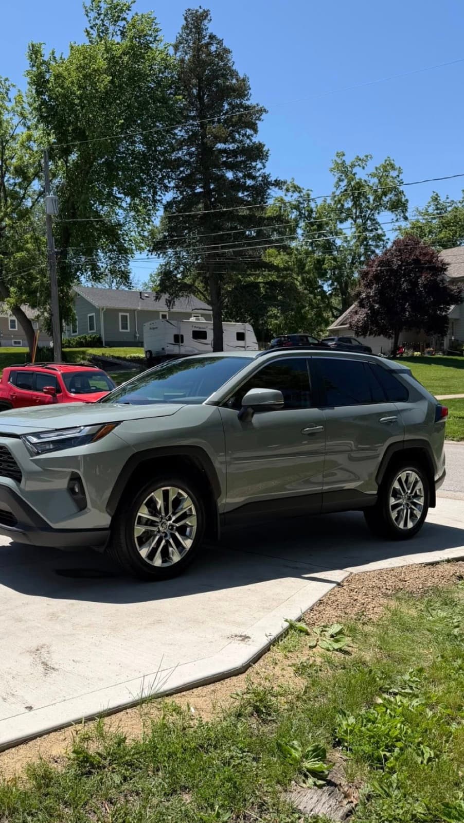 Freshly hand-washed green Toyota RAV4 in a residential driveway